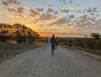 Cloud County cross country athletes on a gravel road at sunset
